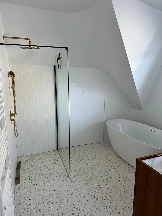 Binnenschilderwerken Antwerpen: badkamer onder het dak met wit geschilderde muren en schuine plafonds
