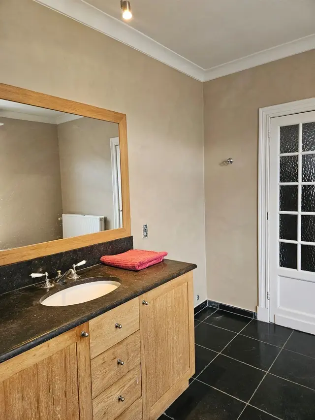 Decoratieve technieken Antwerpen: badkamer met beige kalkverf, houten meubel en wit houtwerk
