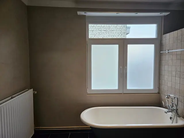 Muurkleur uitproberen: badkamer met warme taupe kalkverf rond het bad
